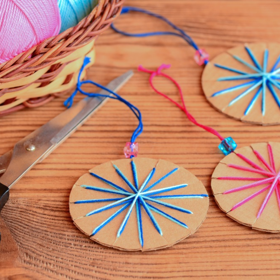 Globuleție simple de brad decupate din cutie de carton și cusute cu fir de bumbac colorat