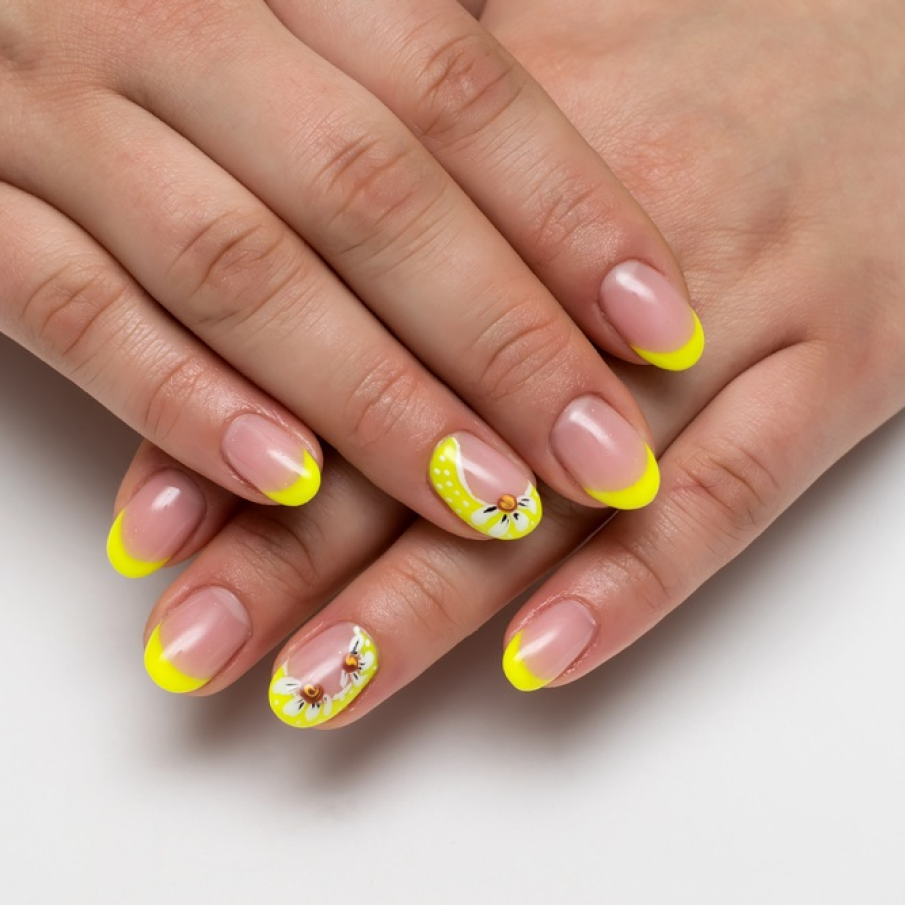 Manichiură french cu motive florale pe unghia inelarului, inspirate de florile de mușețel 