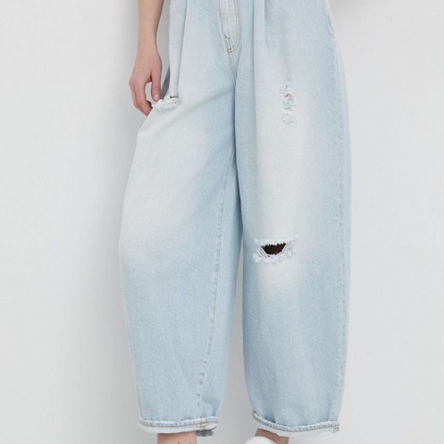 Blugi Armani Exchange cu fason balloon și talie înaltă, pusă în evidență de o curea. Pantalonul este supradimensionat, dezgolind gleznele. 