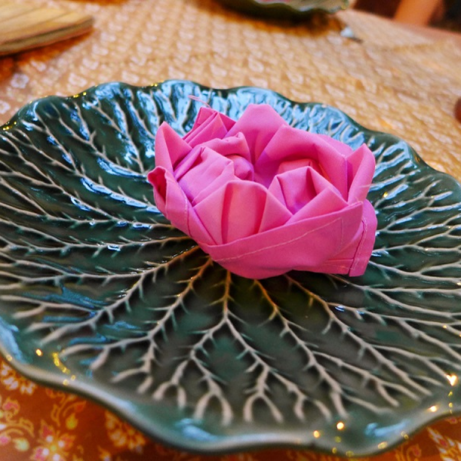 Lotusul plutitor: Servetel textil impaturit in forma de floare 
