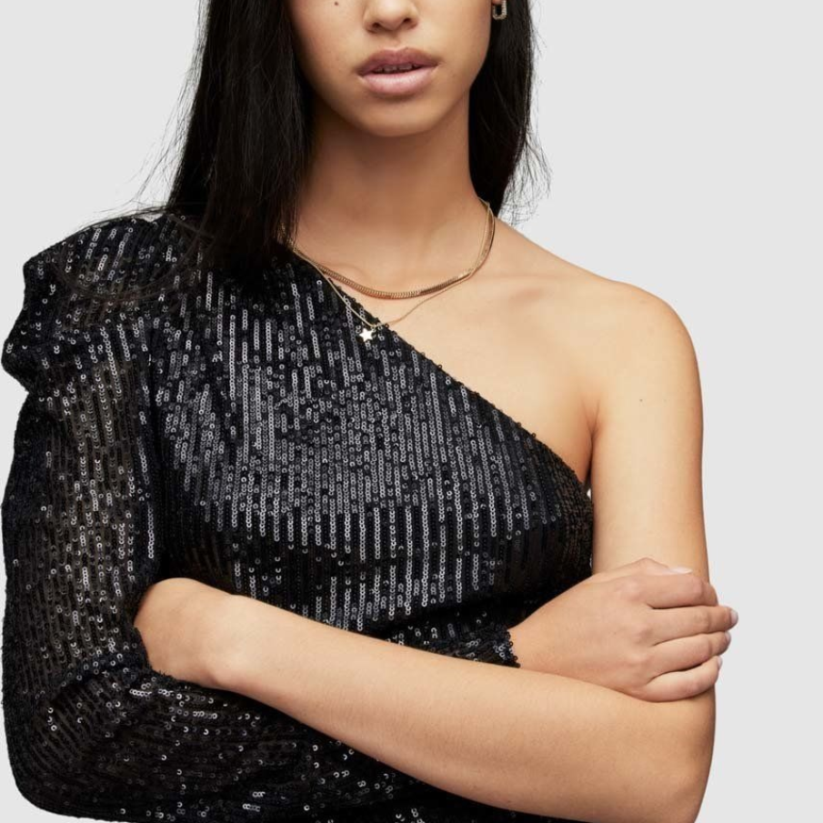Body negru AllSaints, cu paiete strălucitoare și croiala asimetrică, conceput să acopere un singur umăr și să îl dezvăluie pe celălalt. 