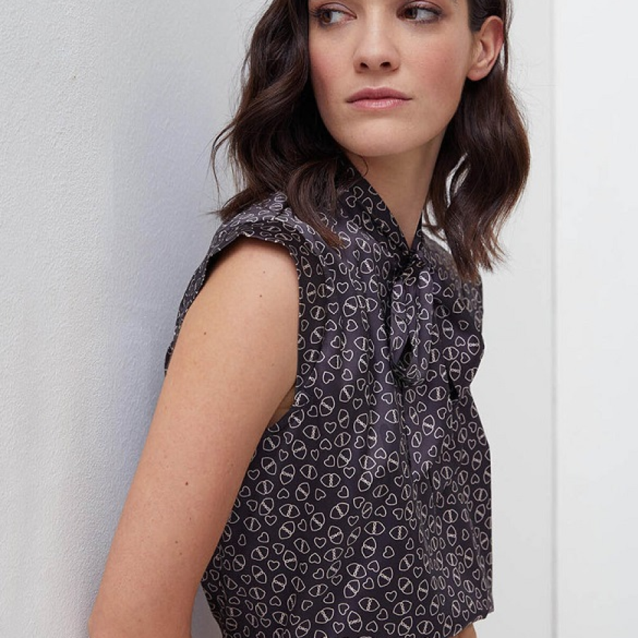 Bluza elegantă fără mâneci de la Motivi, cu fundă la baza gâtului și o multitudine de inimi 