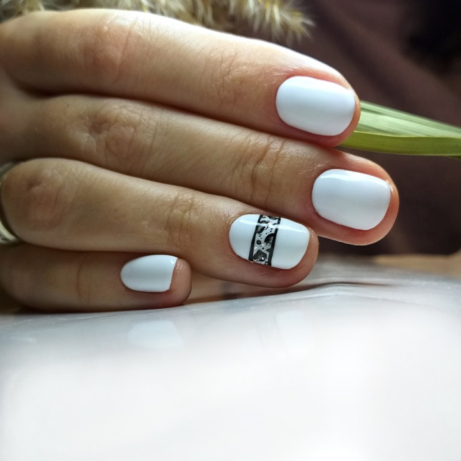 Manichiură cu print tigru minimalist amplasat pe degetul inelarului. 