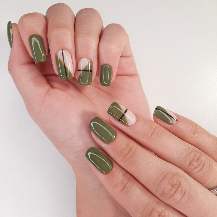 Manichiură verde militar pe jumătate de unghii cu detalii minimaliste precum aceste dungi trasate de maro 