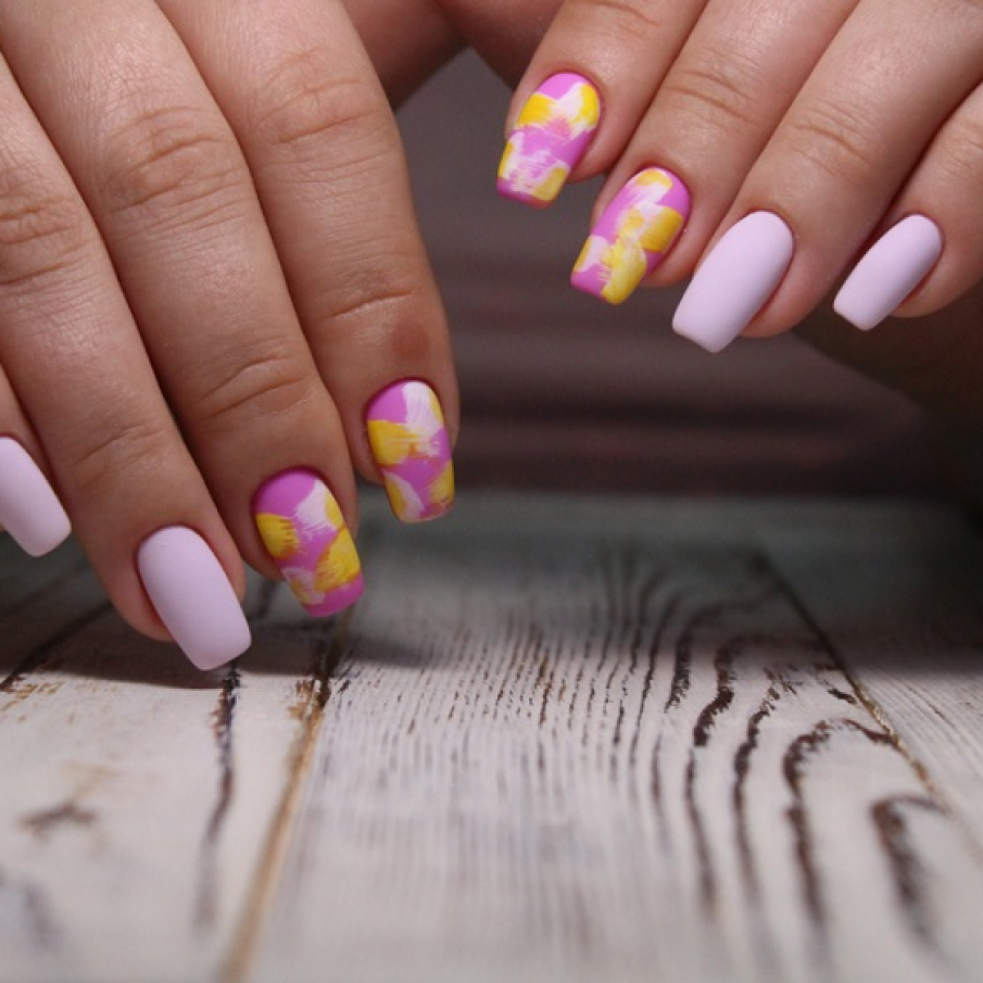 Manichiură lila și roz pastelat cu aspect pictural, de pensulă, și accente de galben pe două dintre unghii 