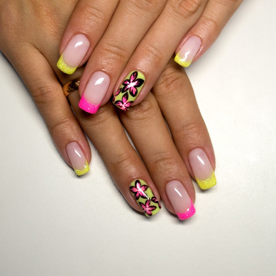 Manichiură franțuzească cu pattern floral statement și marginile unghiilor trasate cu glitter în culori tari, intense