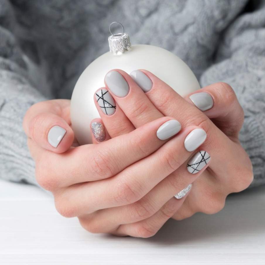 Manichiura de Craicun: dungi intersectate pe linia aratatorului, oja in nuanta de gri sau alb murdar asemenea zapezii si accente stralucitoare de glitter