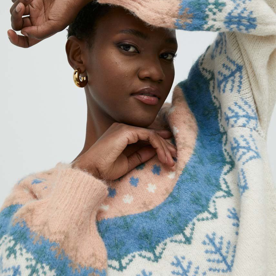 Pulover confecționat din tricot gros, având un imprimeu deosebit ce amintește de albul iernii, fulgii de nea și tonul de bleu al zăpezii