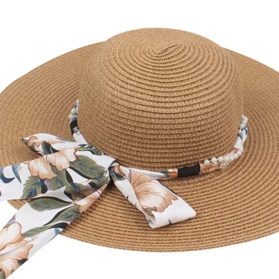 Pălărie de soare damă pentru plajă și protejarea capului de razele soarelui. Dispune de o bandă cu perle și o panglică cu imprimeu floral și fundă
