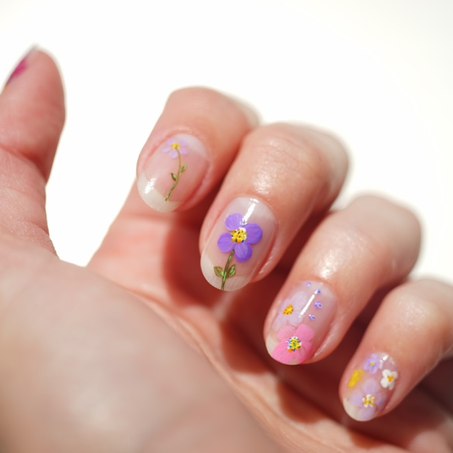 Manichiură simplă, nude, cu floricele delicate pictate cu măiestrie pe unghii