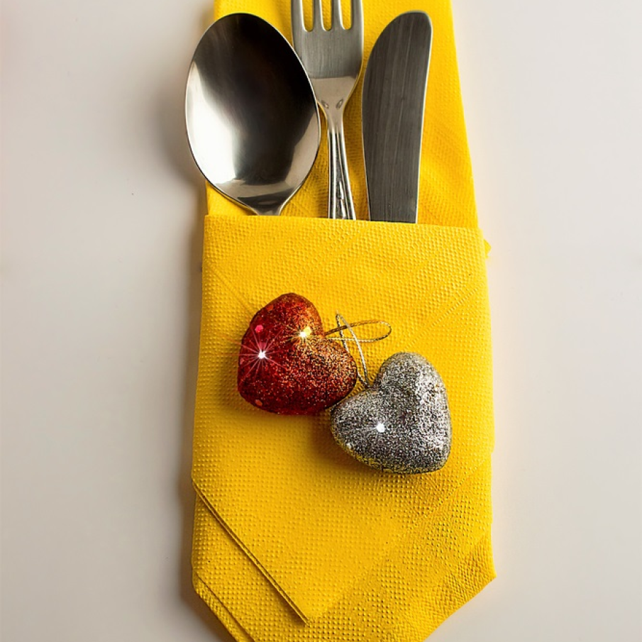 Tacâmuri împăturite în șervețel galben, festiv