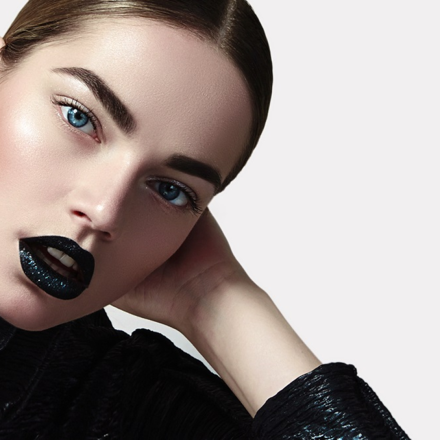 Machiaj de Crăciun în stil gotic, cu ochii subliniați ușor cu ajutorul machiajului și buze dark, fardate cu ruj negru cu accente de glitter