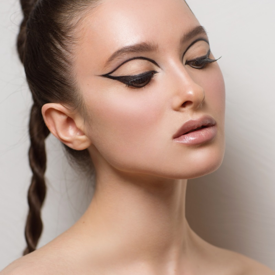 Machiaj grafic de Crăciun, cu dungi și cozi trasate cu tușul de ochi pe pleoapa inferioară, superioară și sub nivelul sprâncenelor