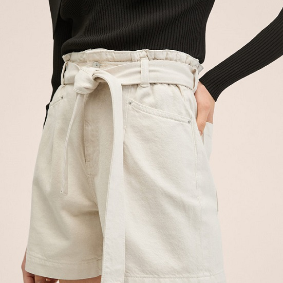 Pantaloni scurți de bumbac în culoarea nisipului alb. Au betelie și cordon pe post de curea pentru a pune în evidență talia și aspectul elegant al ținutei. 