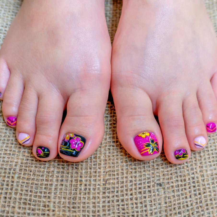 Pedichiură de primăvară realizată cu gel, cu motive japoneze precum flori de sakura pictate pe unghii 