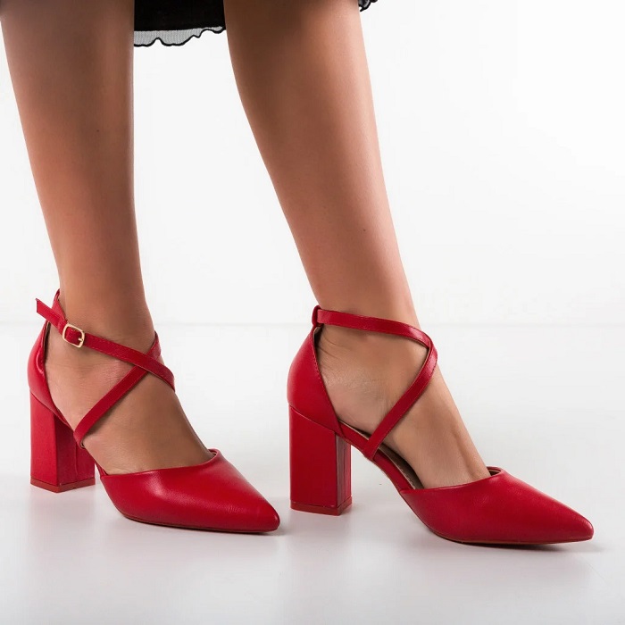 Pantofi roșii cu bretele încrucișate pentru a fi bine fixați pe glezna și a pune în valoare piciorul. Au tocul gros de 8 cm și vârf ascuțit.  